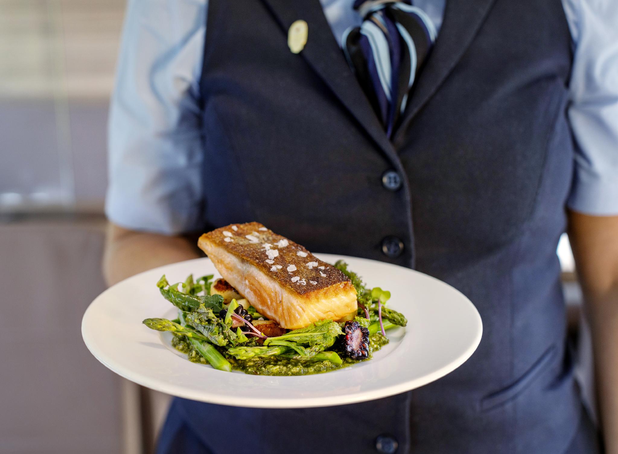 Seared salmon dish presented by Rocky Mountaineer staff